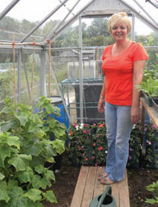 Chris with her row of T&M cucumber plants and infront of her flower pouches full of busy lizzies waiting to hang out