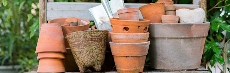 group of terracotta gardening pots and a trowel