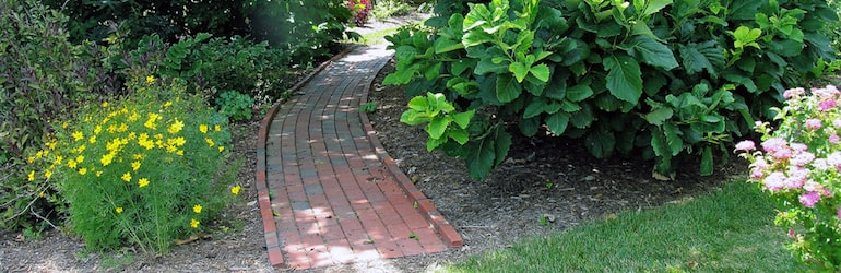 brick garden path with flowers eitherside