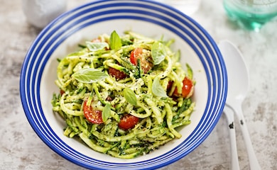 Courgetti and herb dressing in blue striped bowl