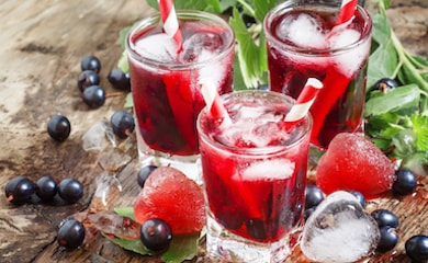 Blackcurrant flavoured drinks next to berries