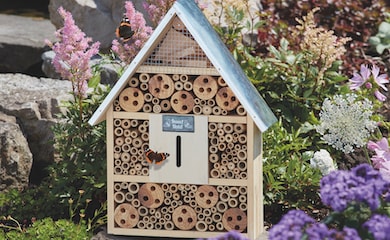 Insect hotel with butterfly approaching