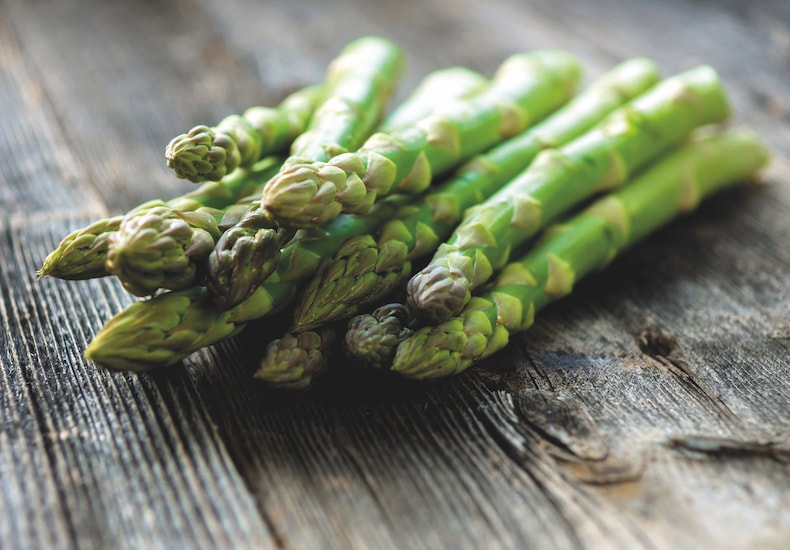 Harvested green asparagus on wooden table