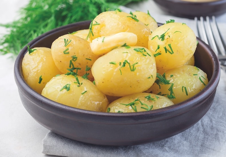 Cooked skinned new potatoes in a bowl
